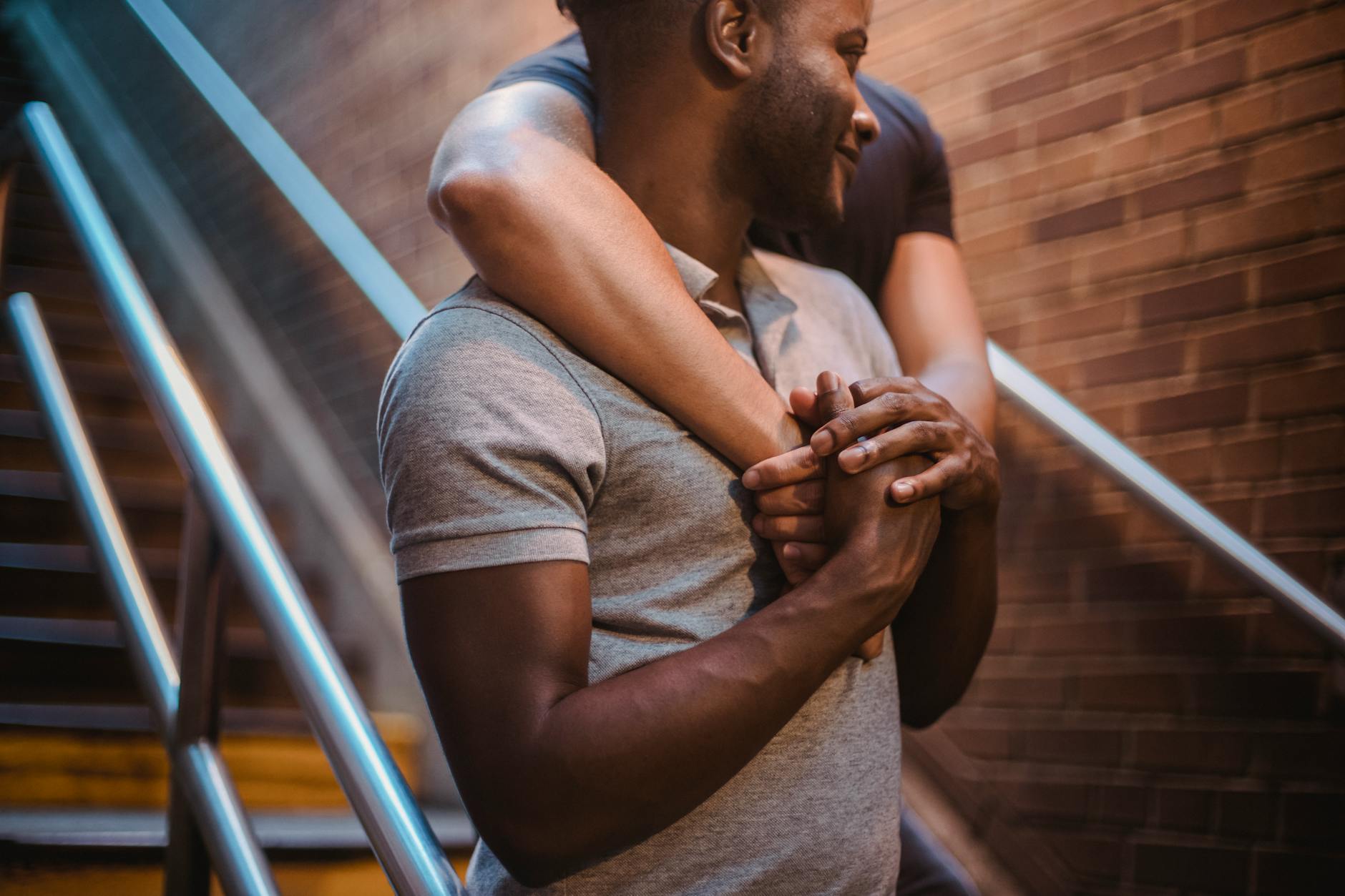 Dwóch mężczyzn obejmuje się ciepło na klatce schodowej