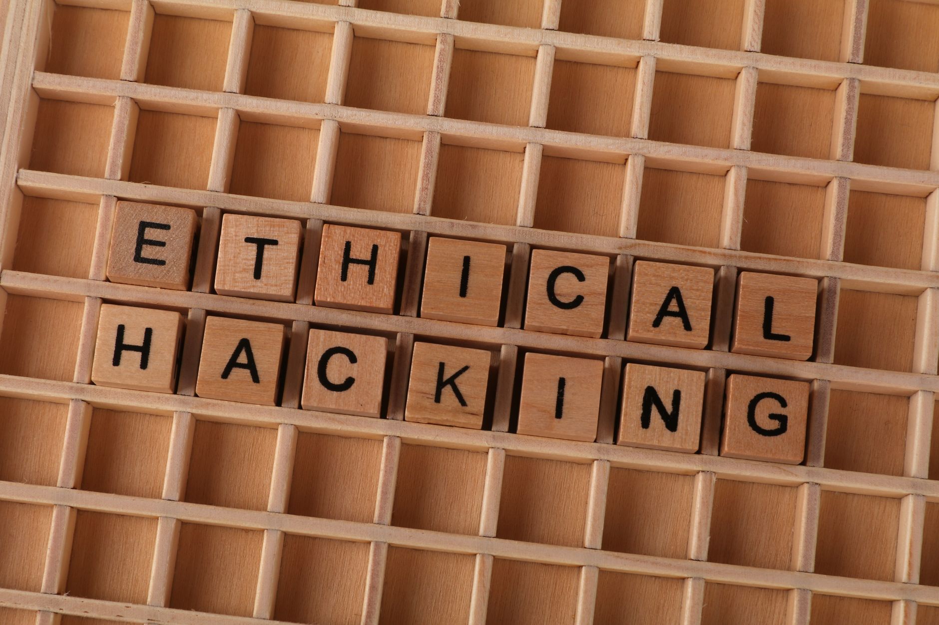 Drewniane klocki układające się w napis ethical hacking na stole